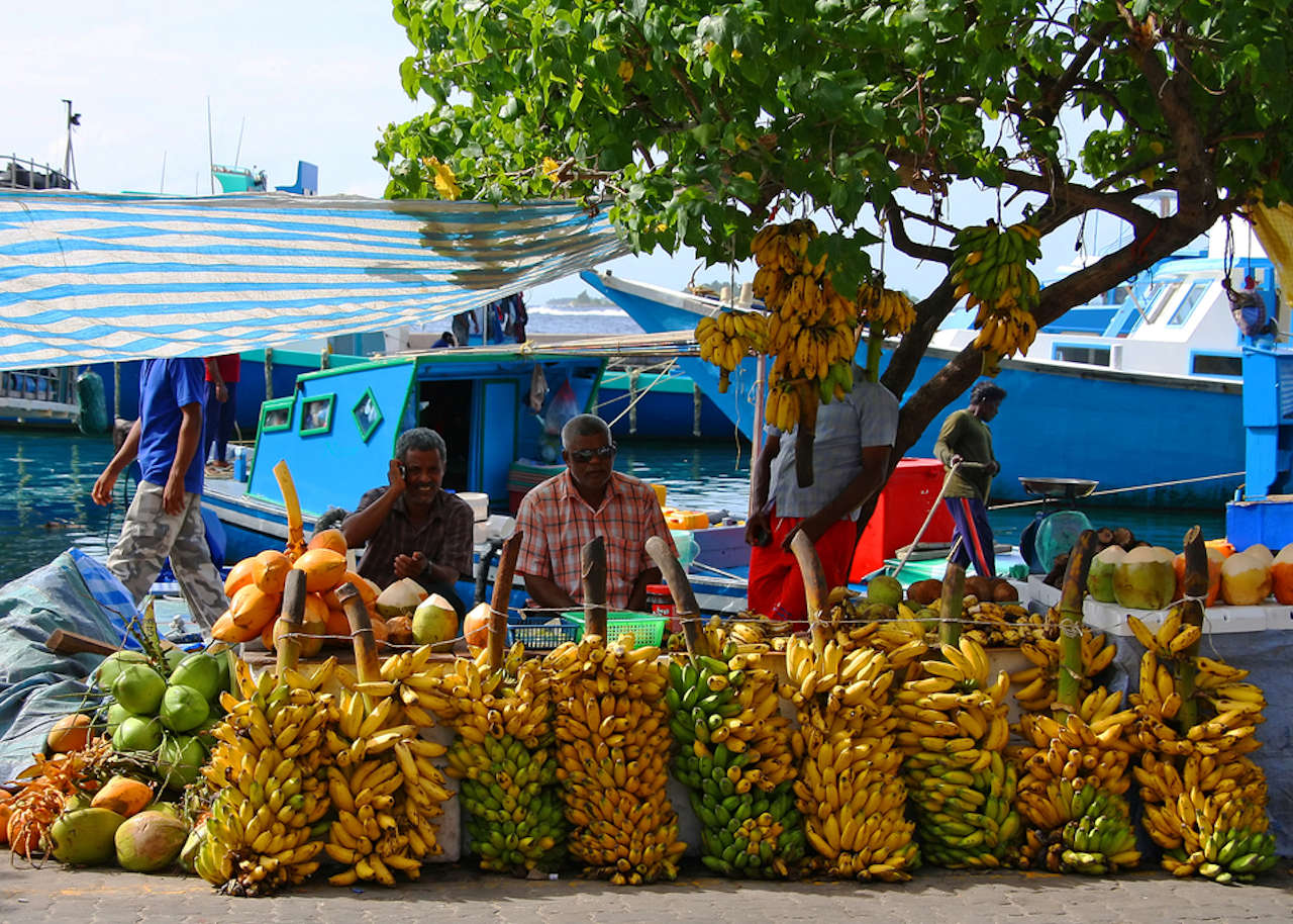 1280 Three street vendors sit by bananas stall shutterstock 43818457